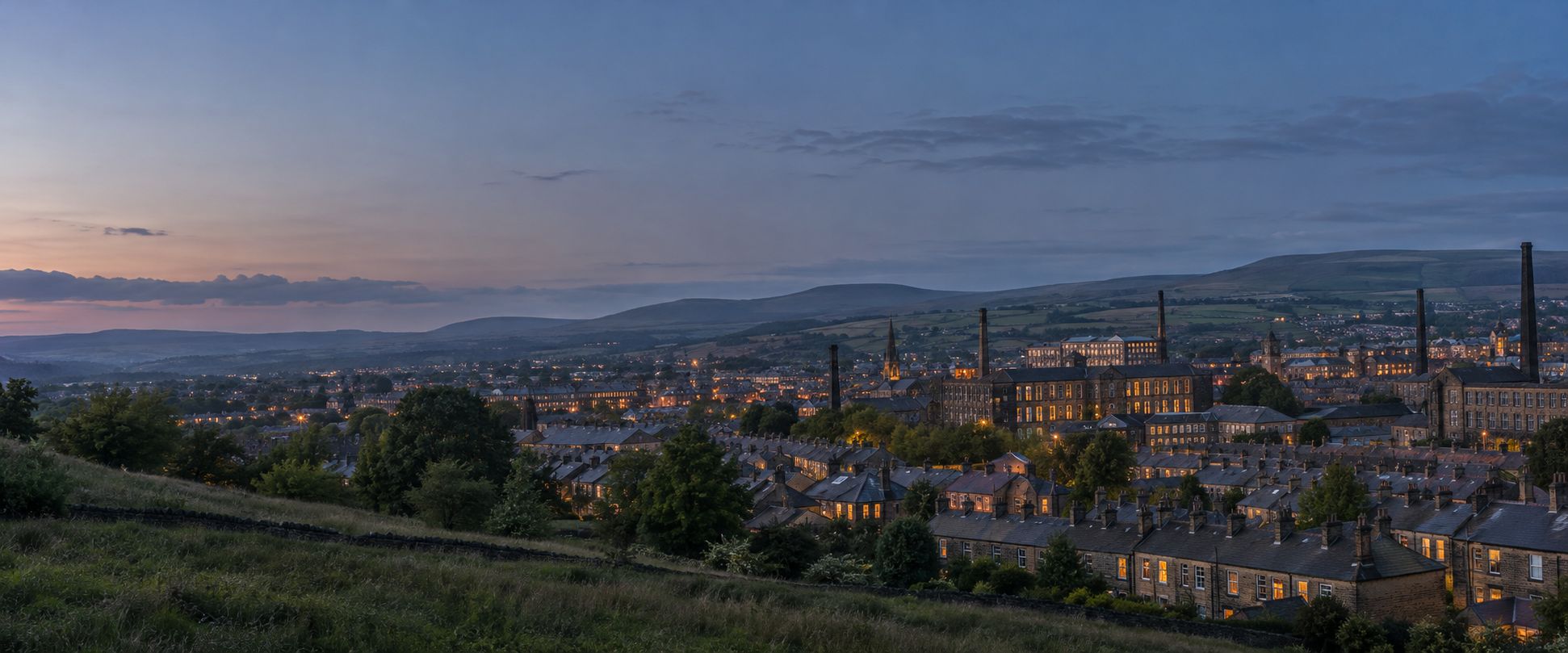 A Lancashire mill town at dusk seen from a hillside